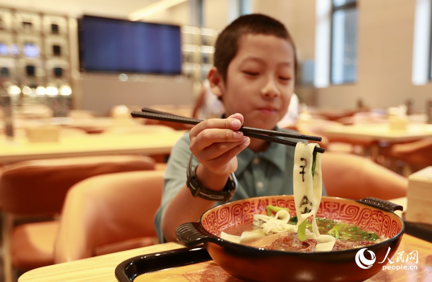 殷墟博物館推出的甲骨文面深受游客喜愛。人民網(wǎng)記者 慎志遠 攝