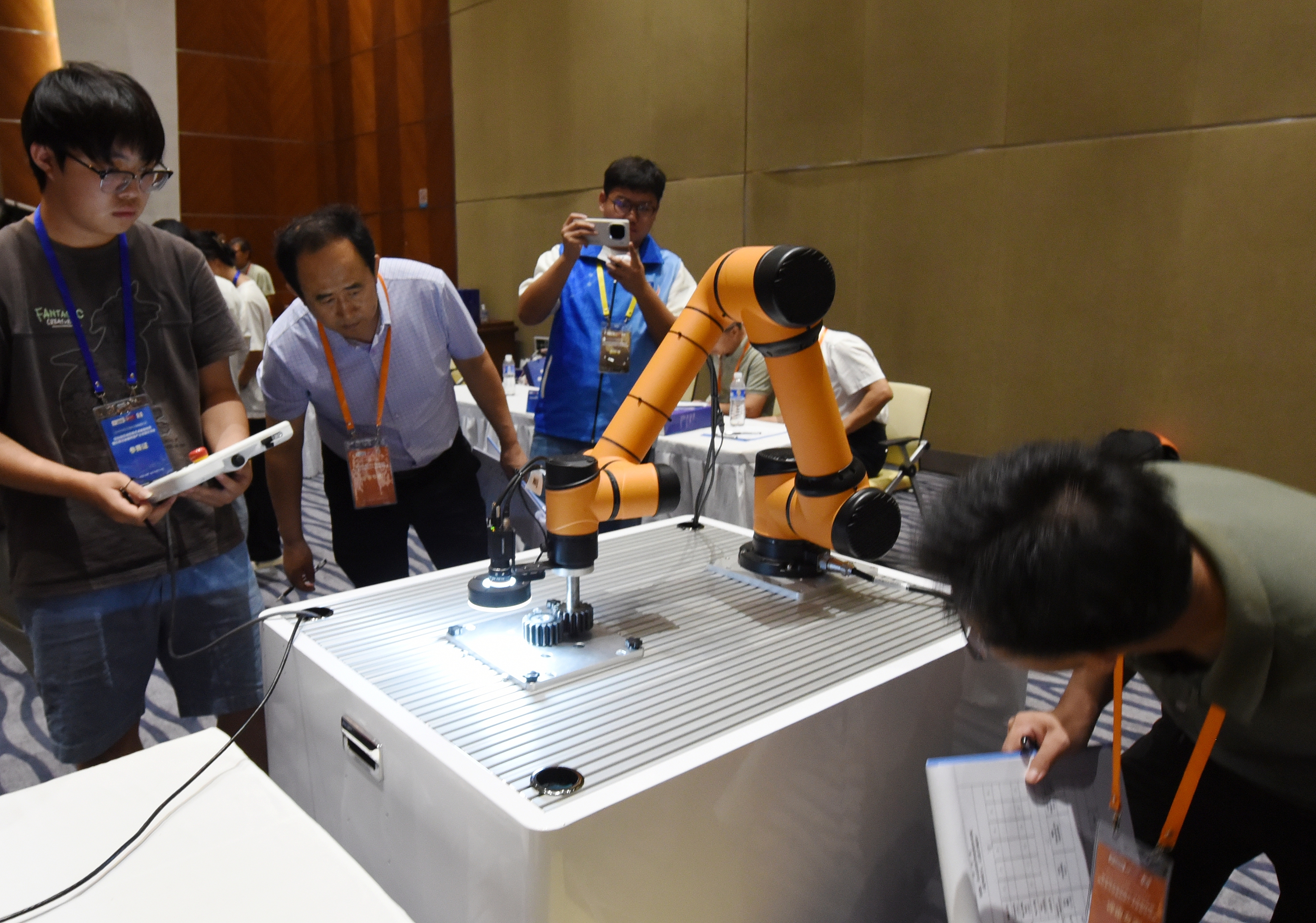 2025年中國(guó)大學(xué)生機(jī)械工程創(chuàng)新創(chuàng)意大賽智能精密裝配賽京津冀魯聯(lián)賽現(xiàn)場(chǎng)，評(píng)委對(duì)參賽選手進(jìn)行實(shí)操調(diào)試評(píng)比。